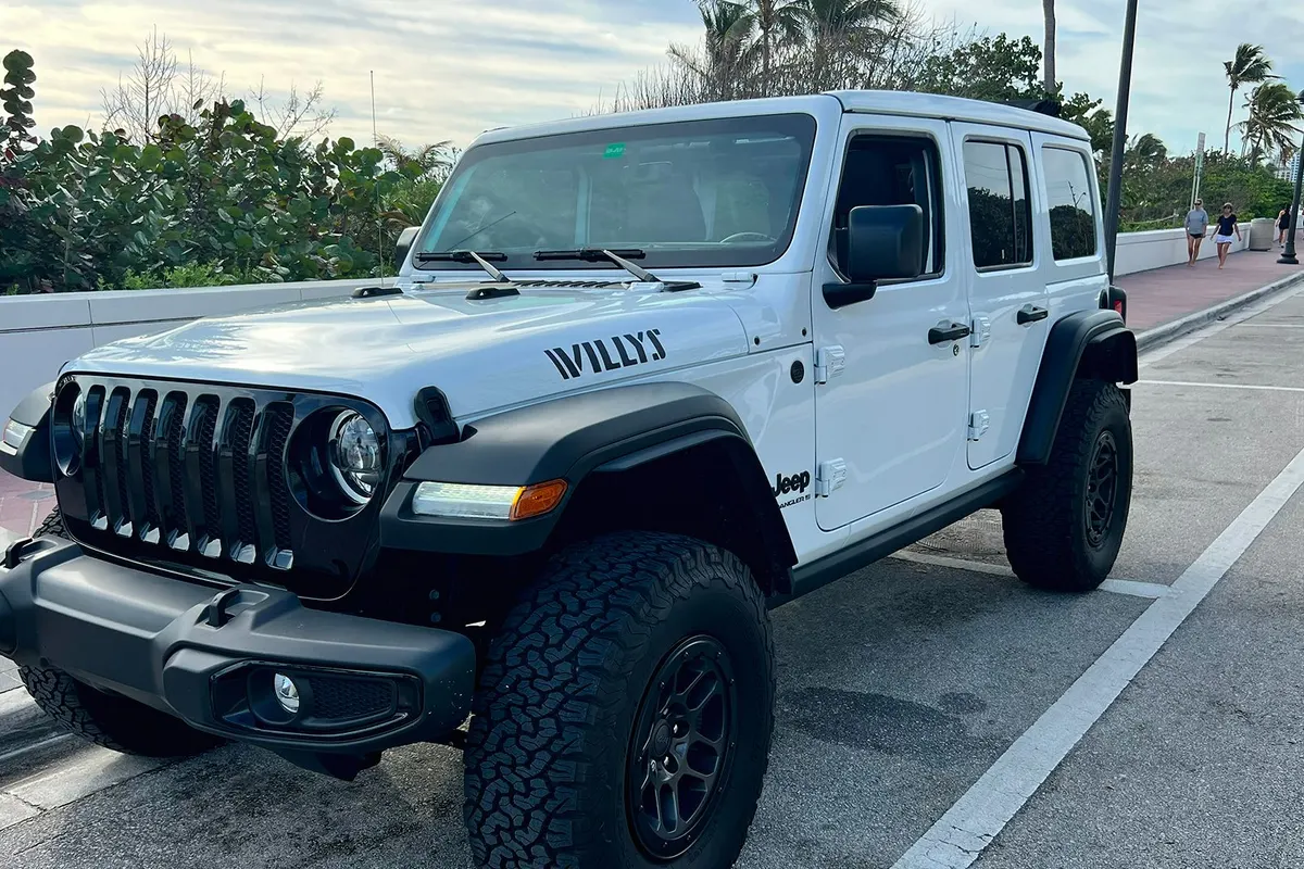 White Jeep Wrangler Willys delivered at a hotel entrance